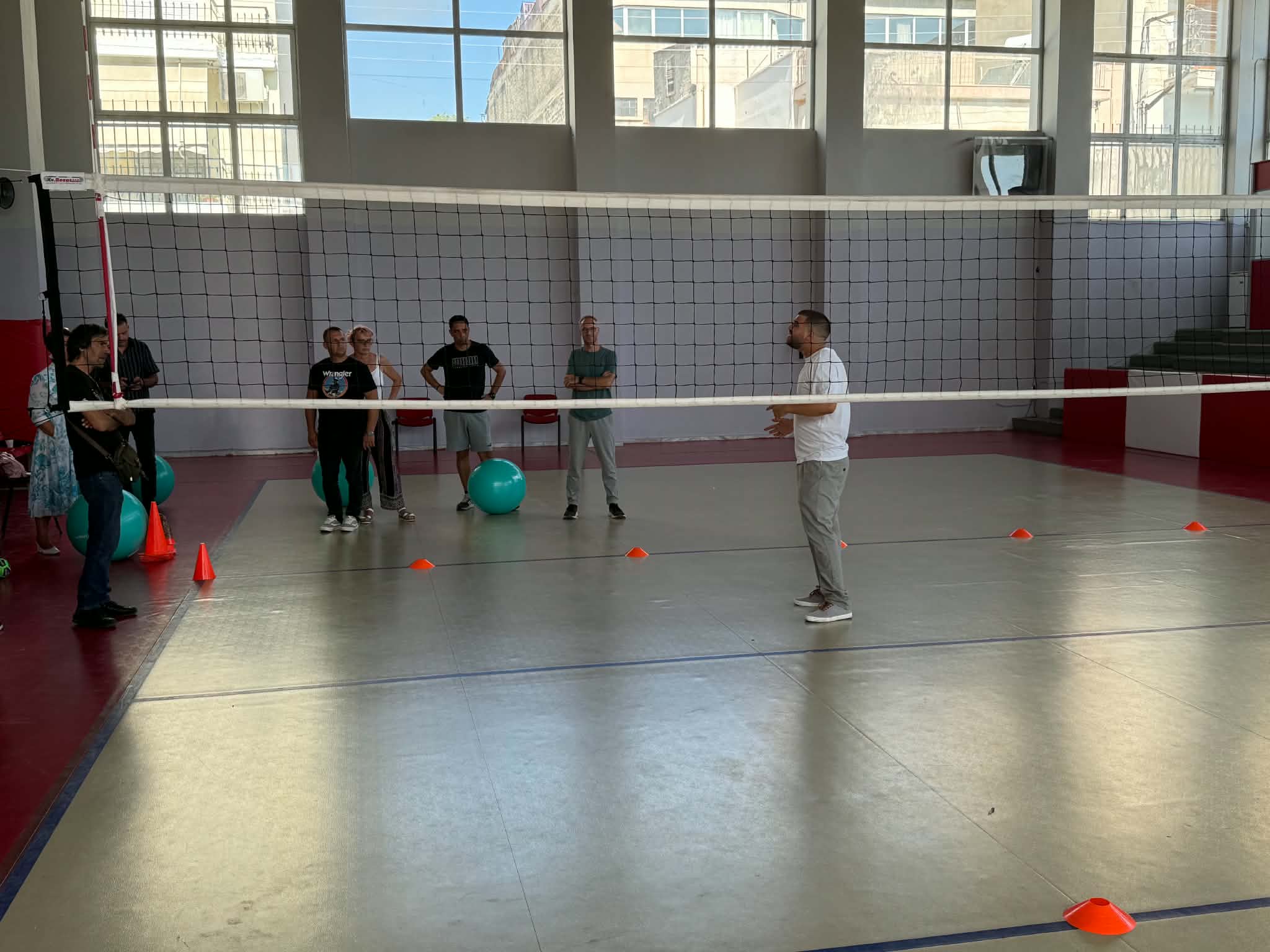 Practical sport session in a gymnasium with participants, exercise balls and cones during the second training event in Athens